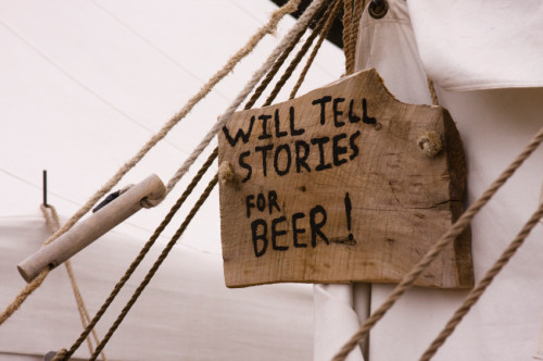 Sign pegged on a tent: will tell stories for beer