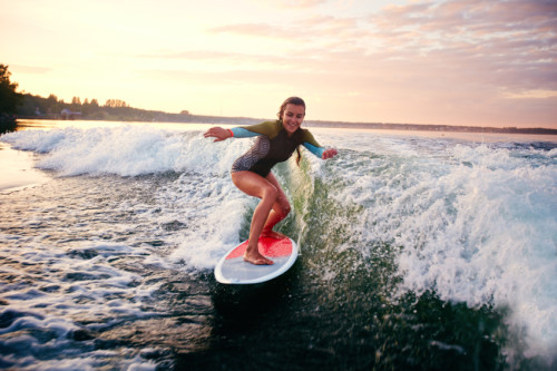 Young woman surfboarding at summer resort