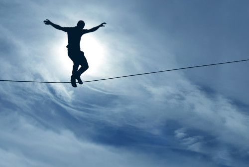 Silhouette of a man balancing on a tightrope 